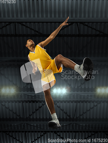 Image of Young professional basketball player in action, motion isolated on black background, look from the bottom. Concept of sport, movement, energy and dynamic.