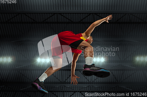 Image of Young professional basketball player in action, motion isolated on black background, look from the bottom. Concept of sport, movement, energy and dynamic.