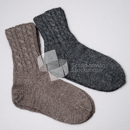 Image of  two pair of woolen knitted socks on a neutral background
