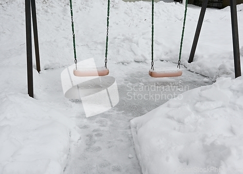 Image of swing on the playground in the yard in winter