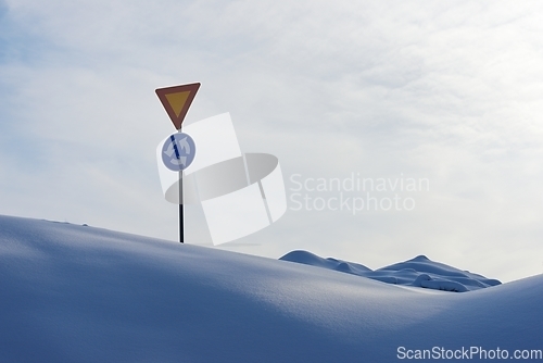 Image of roundabout signs and give way in winter among snowdrifts in Finl