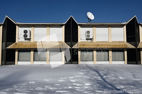 Image of abandoned non residential building  with satellite dish on the r