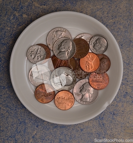 Image of small american coins on a white saucer