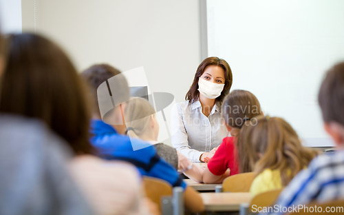 Image of teacher in mask with group of children at school