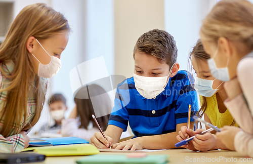 Image of group of students in masks learning at school