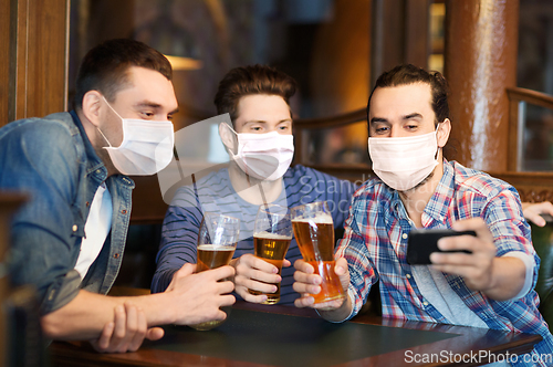 Image of men in masks take selfie and drink beer at bar