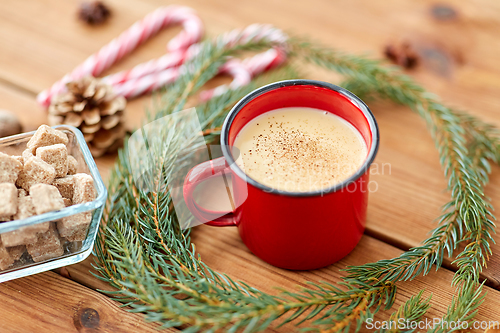 Image of cup of eggnog, fir branches, gingerbread and sugar