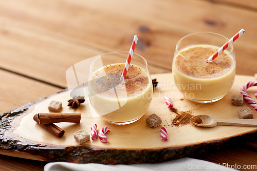 Image of glasses of eggnog, ingredients and spices on wood