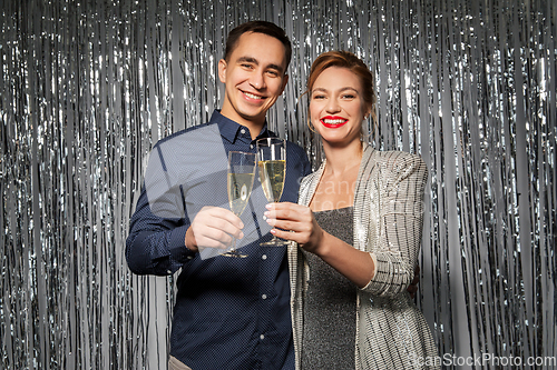 Image of happy couple toasting champagne glasses at party