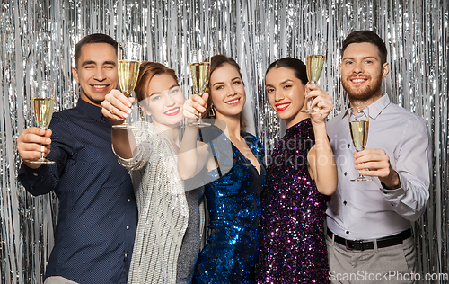 Image of happy friends toasting champagne glasses at party