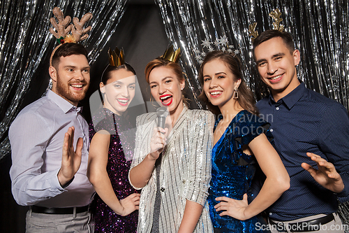 Image of friends with microphone singing at christmas party