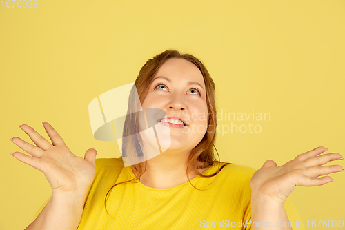 Image of Beautiful caucasian plus size model isolated on yellow studio background. Concept of inclusion, human emotions, facial expression