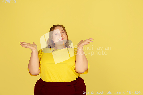 Image of Beautiful caucasian plus size model isolated on yellow studio background. Concept of inclusion, human emotions, facial expression