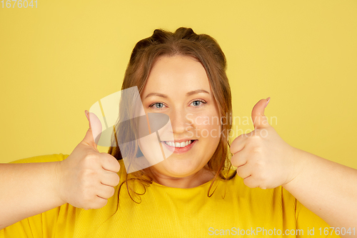 Image of Beautiful caucasian plus size model isolated on yellow studio background. Concept of inclusion, human emotions, facial expression