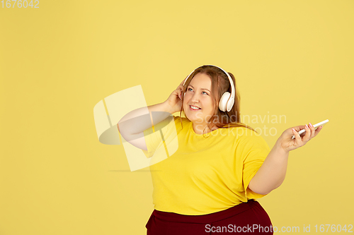 Image of Beautiful caucasian plus size model isolated on yellow studio background. Concept of inclusion, human emotions, facial expression