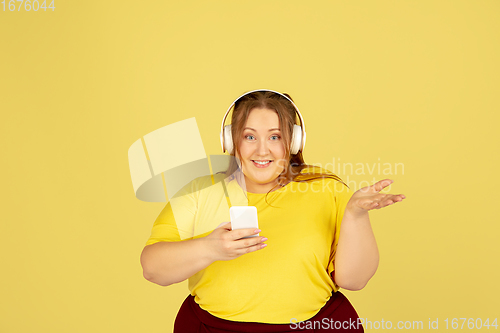 Image of Beautiful caucasian plus size model isolated on yellow studio background. Concept of inclusion, human emotions, facial expression