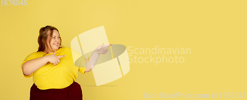 Image of Beautiful caucasian plus size model isolated on yellow studio background. Concept of inclusion, human emotions, facial expression