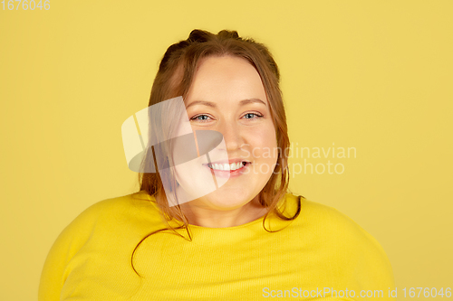 Image of Beautiful caucasian plus size model isolated on yellow studio background. Concept of inclusion, human emotions, facial expression