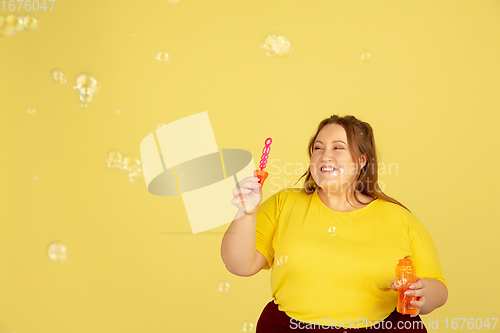 Image of Beautiful caucasian plus size model isolated on yellow studio background. Concept of inclusion, human emotions, facial expression