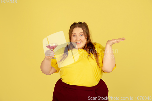 Image of Beautiful caucasian plus size model isolated on yellow studio background. Concept of inclusion, human emotions, facial expression