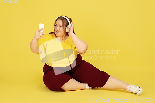 Image of Beautiful caucasian plus size model isolated on yellow studio background. Concept of inclusion, human emotions, facial expression