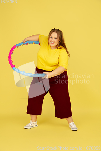 Image of Beautiful caucasian plus size model isolated on yellow studio background. Concept of inclusion, human emotions, facial expression