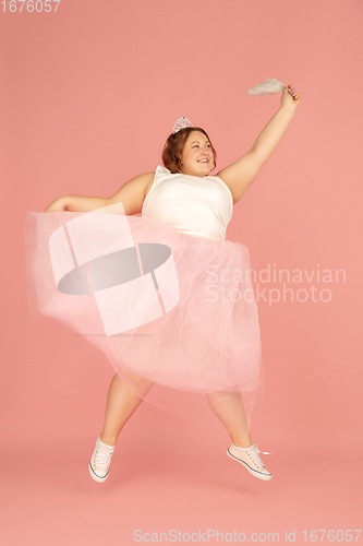 Image of Beautiful caucasian plus size model isolated on pink studio background. Concept of inclusion, human emotions, facial expression