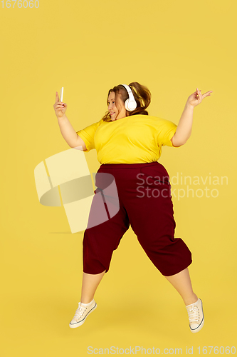 Image of Beautiful caucasian plus size model isolated on yellow studio background. Concept of inclusion, human emotions, facial expression