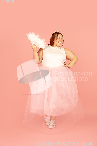 Image of Beautiful caucasian plus size model isolated on pink studio background. Concept of inclusion, human emotions, facial expression