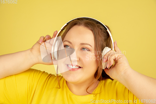 Image of Beautiful caucasian plus size model isolated on yellow studio background. Concept of inclusion, human emotions, facial expression