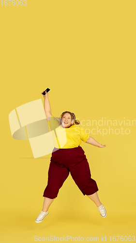 Image of Beautiful caucasian plus size model isolated on yellow studio background. Concept of inclusion, human emotions, facial expression