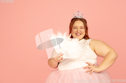 Image of Beautiful caucasian plus size model isolated on pink studio background. Concept of inclusion, human emotions, facial expression