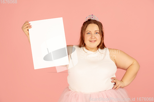 Image of Beautiful caucasian plus size model isolated on pink studio background. Concept of inclusion, human emotions, facial expression