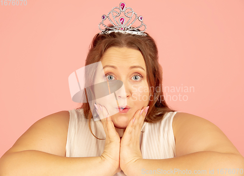 Image of Beautiful caucasian plus size model isolated on pink studio background. Concept of inclusion, human emotions, facial expression