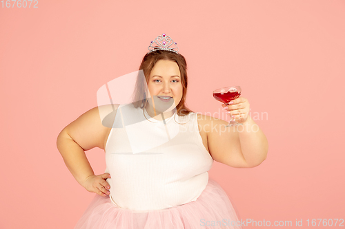 Image of Beautiful caucasian plus size model isolated on pink studio background. Concept of inclusion, human emotions, facial expression