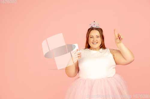 Image of Beautiful caucasian plus size model isolated on pink studio background. Concept of inclusion, human emotions, facial expression