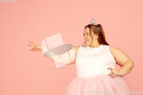 Image of Beautiful caucasian plus size model isolated on pink studio background. Concept of inclusion, human emotions, facial expression