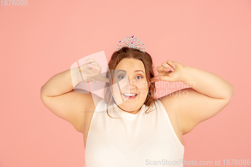 Image of Beautiful caucasian plus size model isolated on pink studio background. Concept of inclusion, human emotions, facial expression