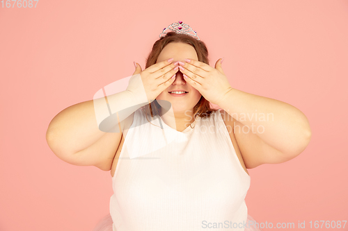 Image of Beautiful caucasian plus size model isolated on pink studio background. Concept of inclusion, human emotions, facial expression