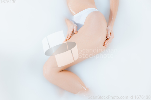 Image of Close up female body in the milk bath with soft white glowing. Copyspace for advertising. Beauty, fashion, style, bodycare concept.