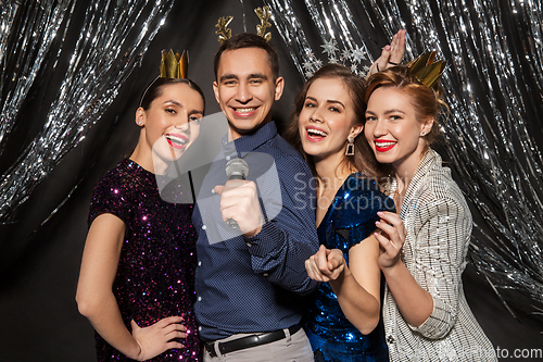 Image of friends with microphone singing at christmas party