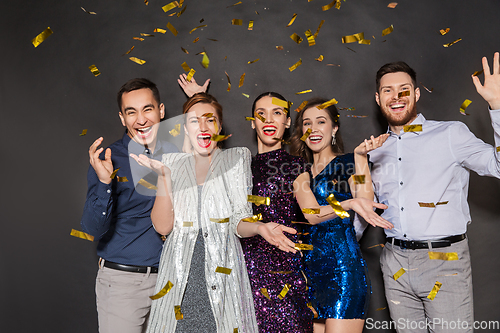 Image of happy friends at party under confetti over black