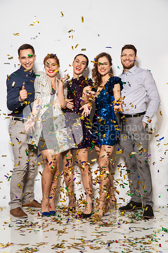 Image of happy friends at party under confetti over white