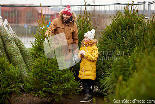 Image of happy family choosing christmas tree at market