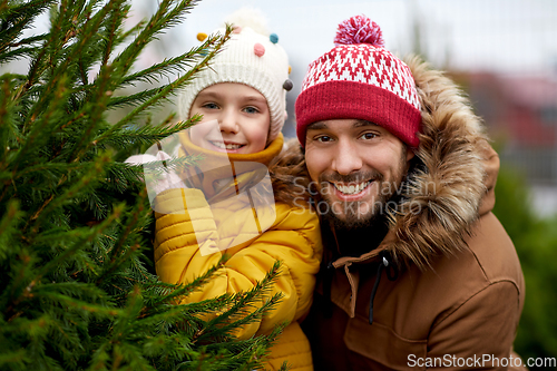 Image of happy family choosing christmas tree at market