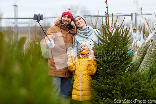 Image of family taking selfie with christmas tree at market