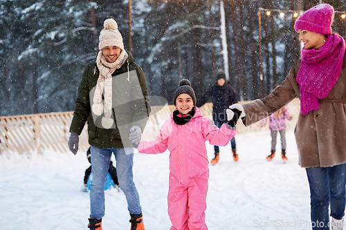 Image of happy family at outdoor skating rink in winter