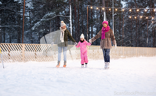 Image of happy family at outdoor skating rink in winter