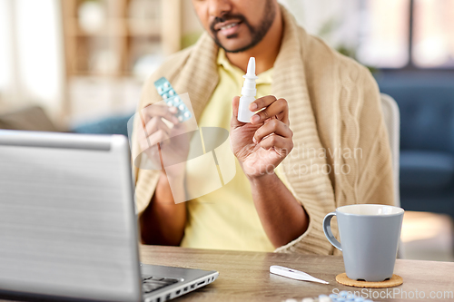 Image of sick man thermometer having video call on laptop