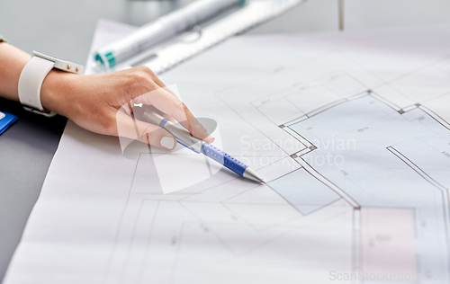 Image of architect with blueprint working at office